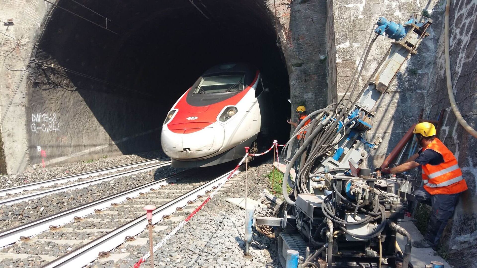 Un treno rosso e bianco esce da un tunnel