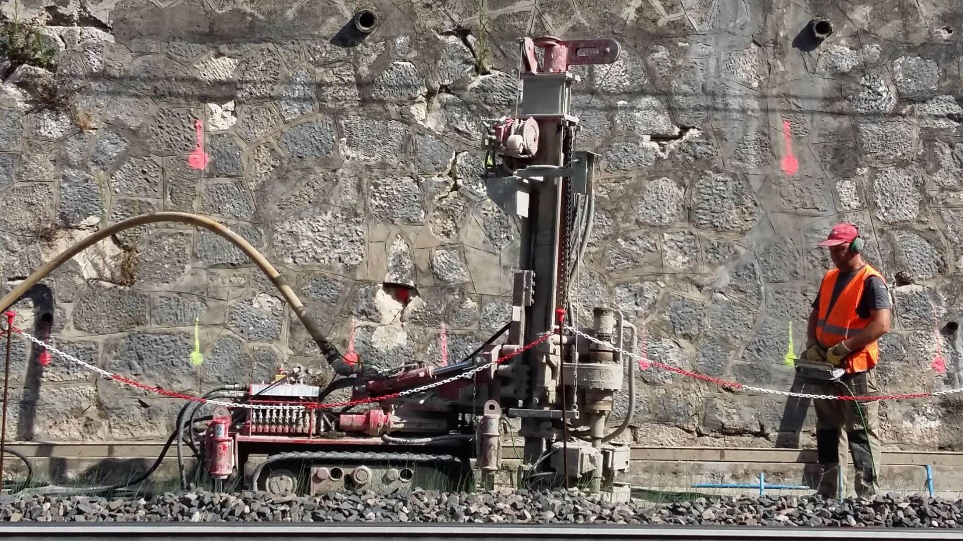 Un uomo è in piedi accanto a una macchina sui binari di un treno.