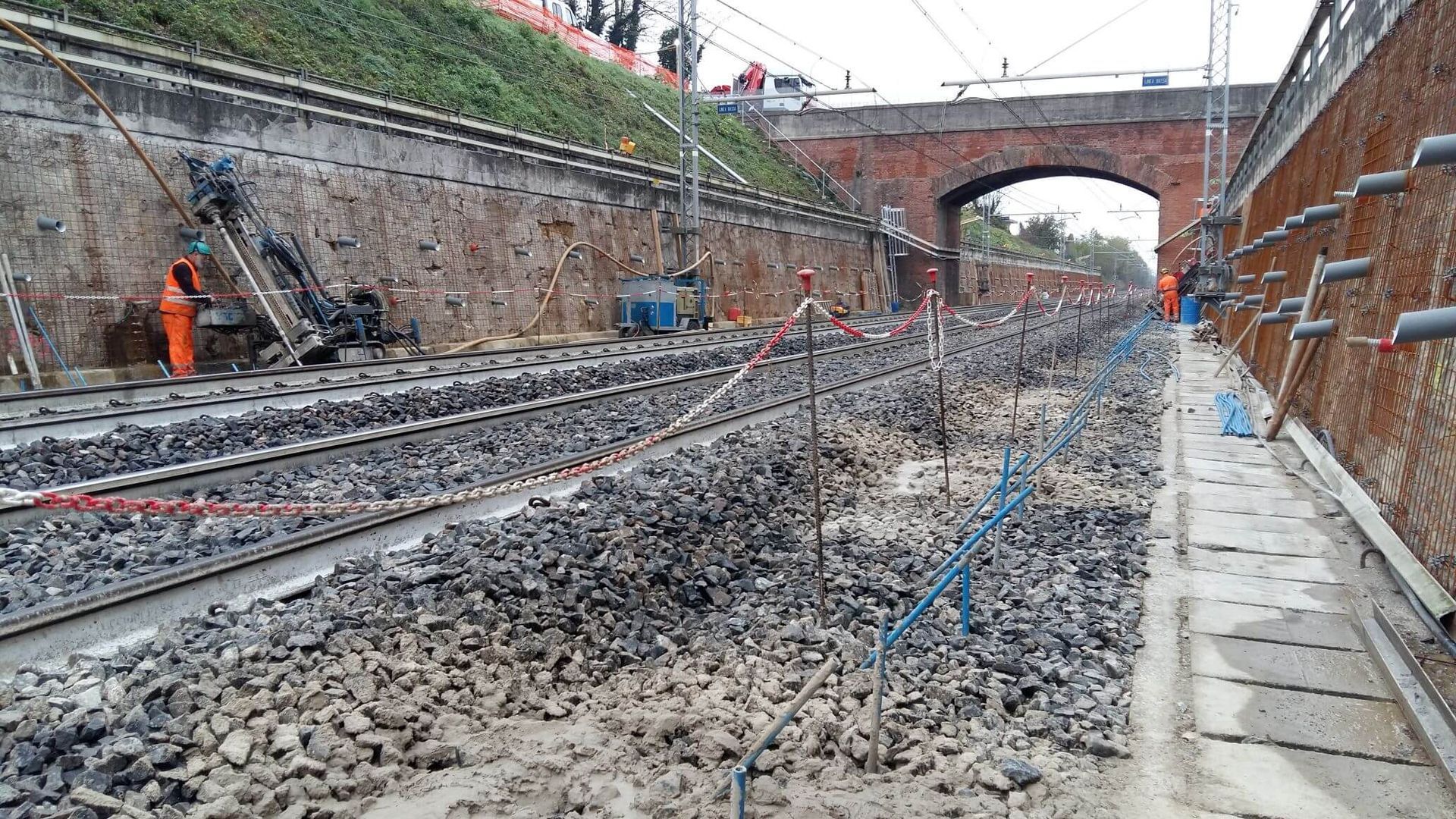 Un binario ferroviario in costruzione con un ponte sullo sfondo.