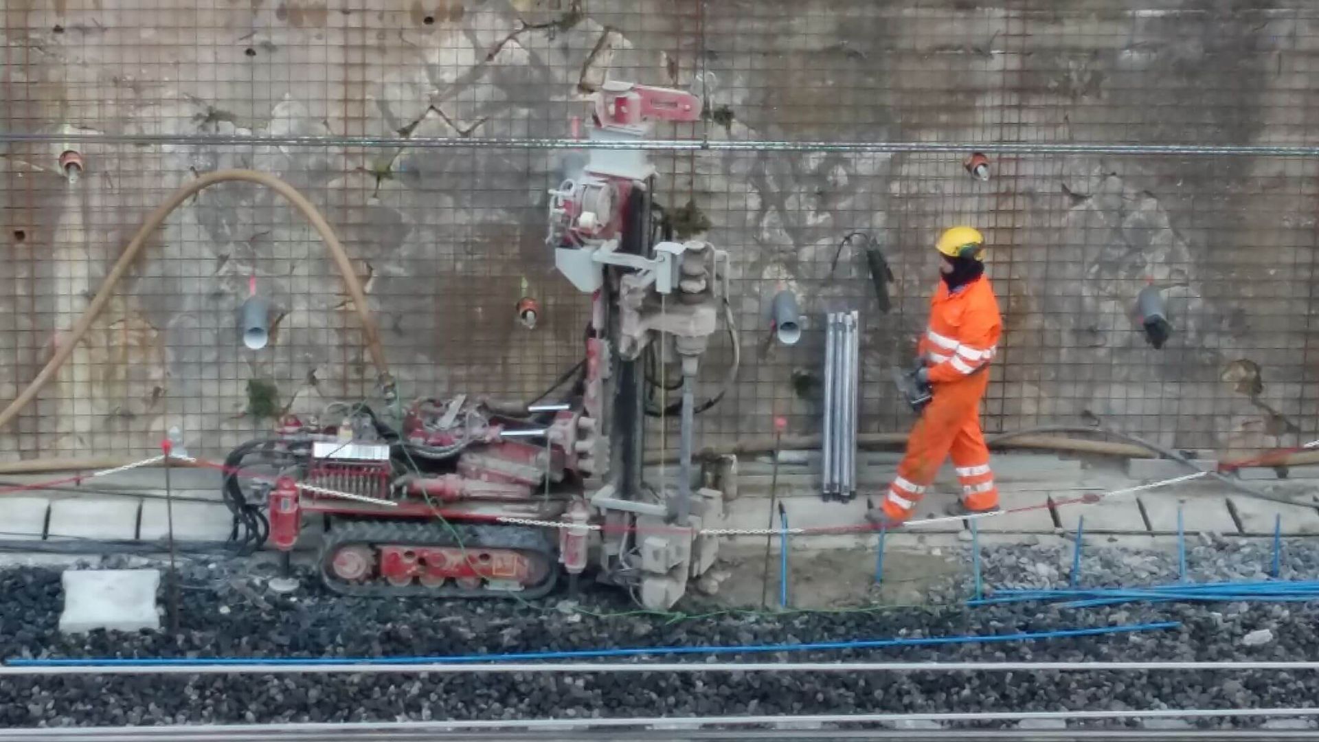 Un operaio edile è in piedi accanto a una macchina.