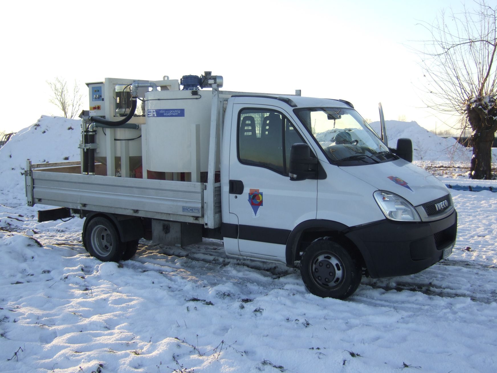 Un camion bianco è parcheggiato nella neve.