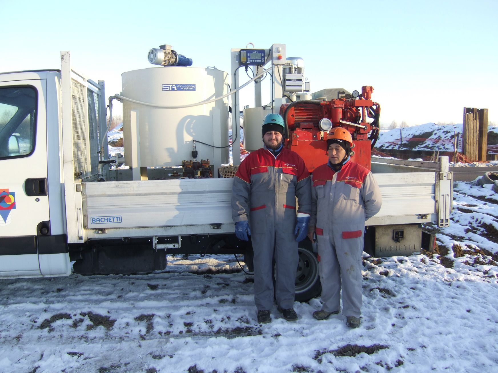 Due operai sono in piedi davanti a un camion bianco 