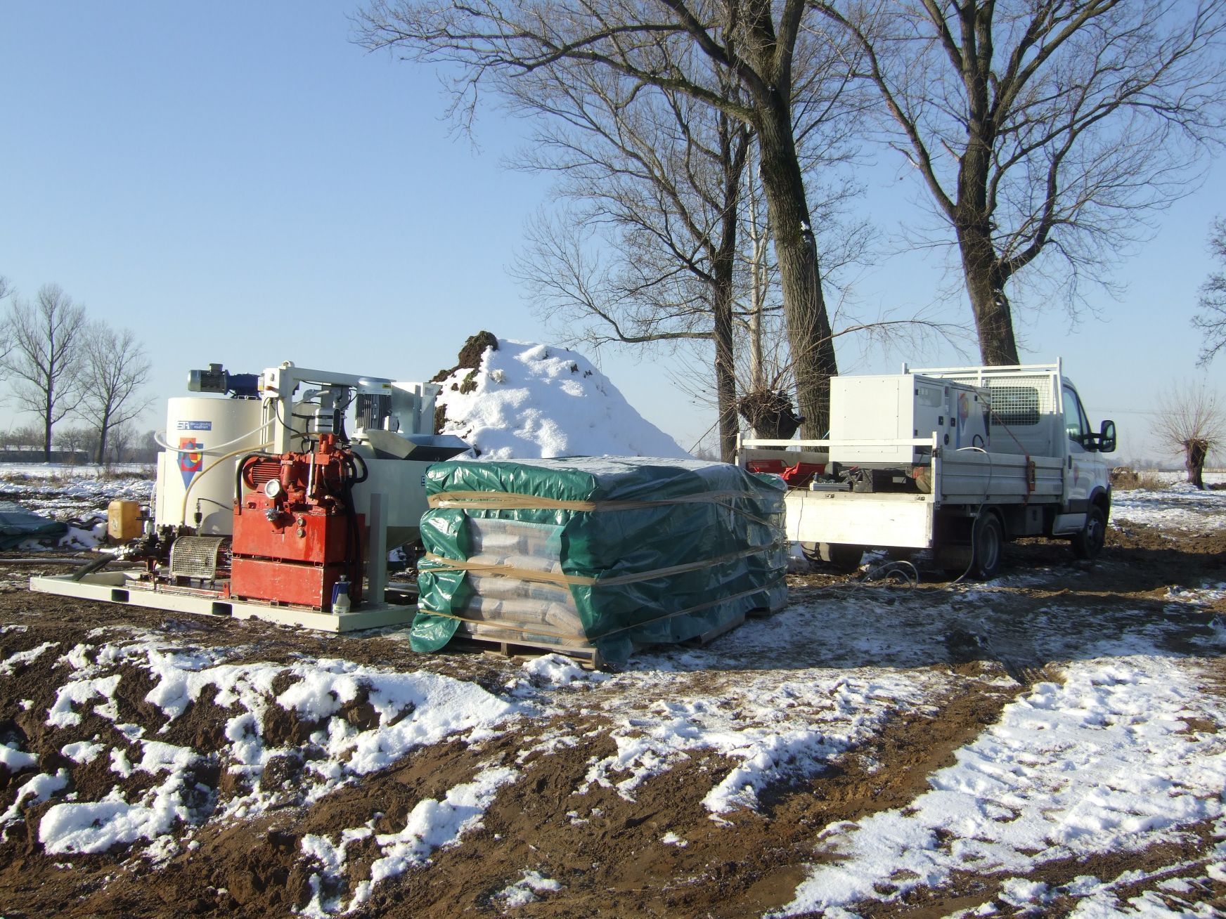 Un camion bianco è parcheggiato in un campo innevato