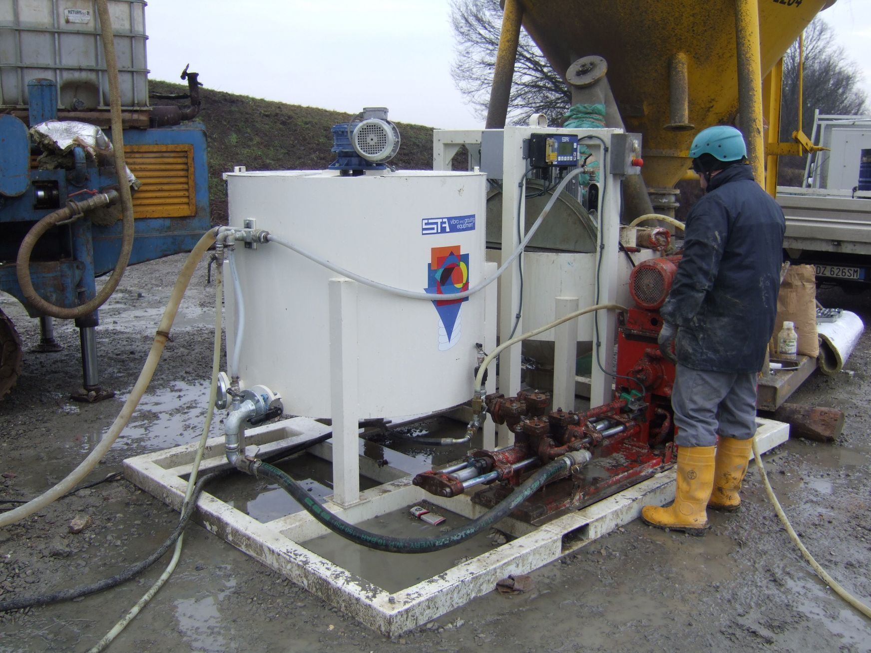 Un operaio è in piedi accanto a una macchina per il consolidamento dei terreni