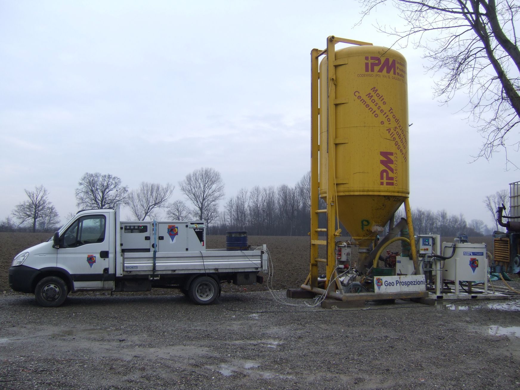 Un camion bianco è parcheggiato accanto a un silo giallo