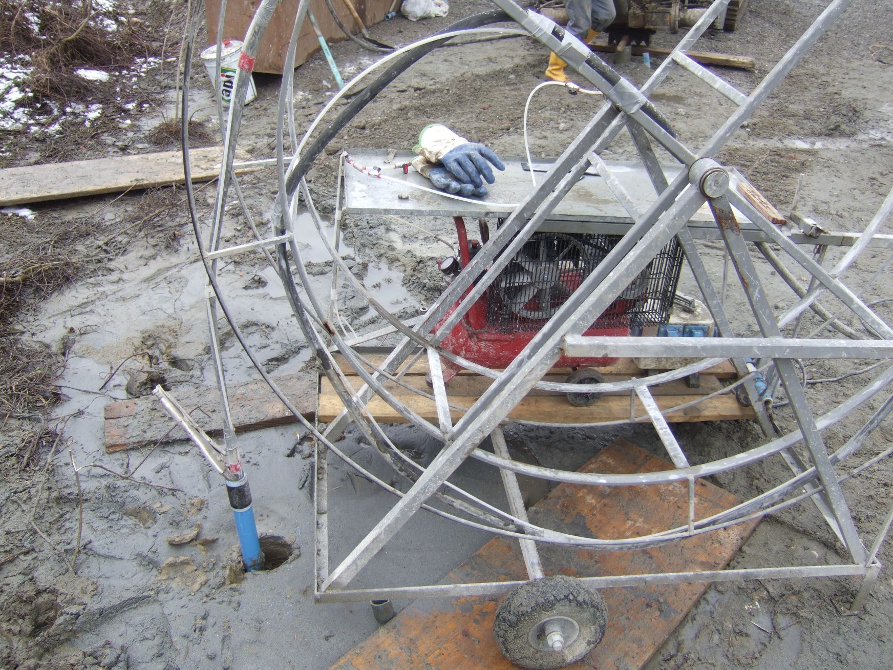 Una persona che indossa guanti blu sta lavorando su una macchina nella polvere.