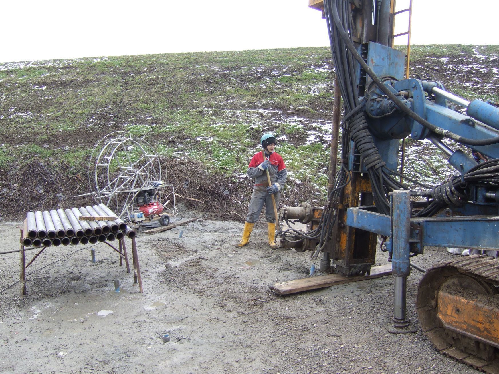 Un uomo è in piedi accanto a una macchina in un campo.