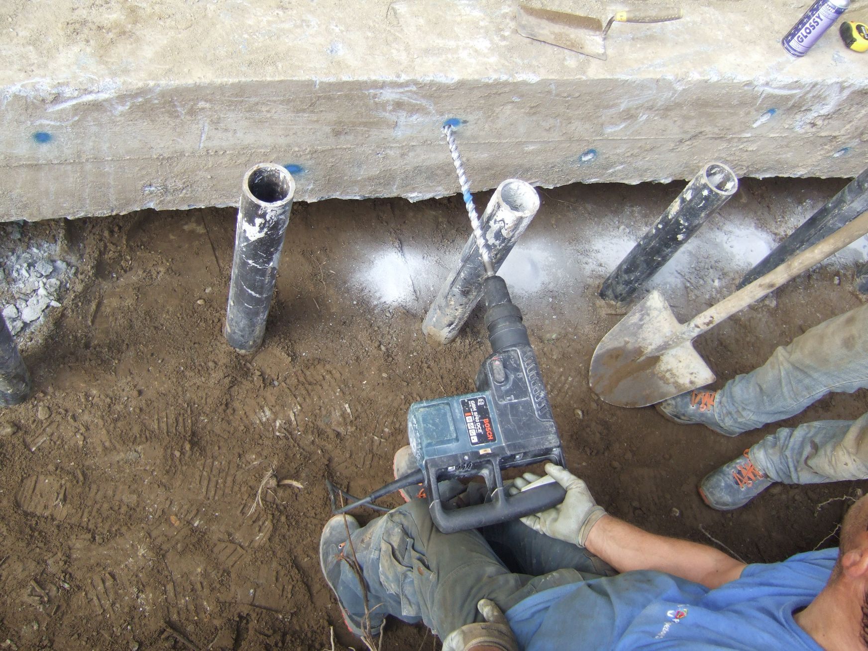 Un uomo sta usando un trapano per scavare una buca nel terreno