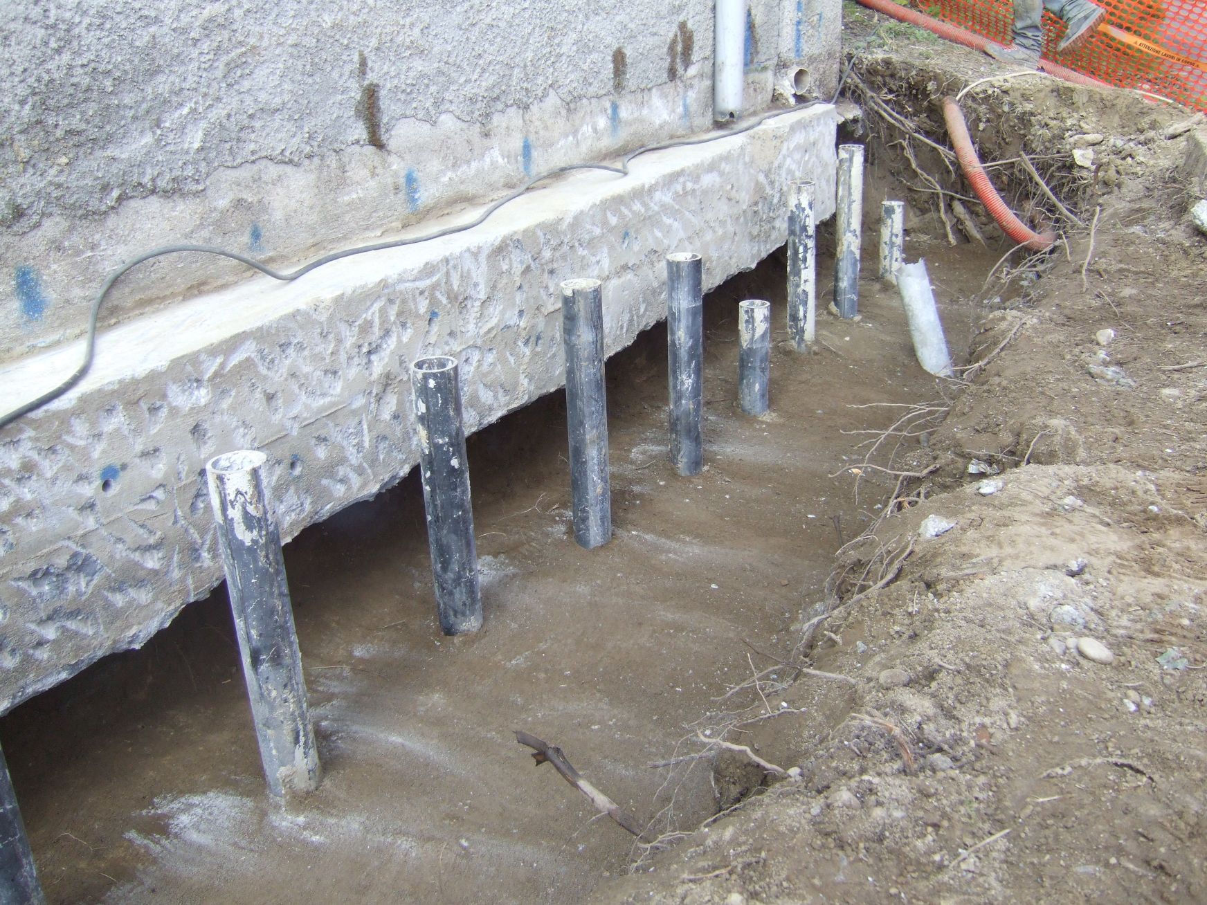 Un muro di cemento con un mucchio di pali di metallo al suo interno