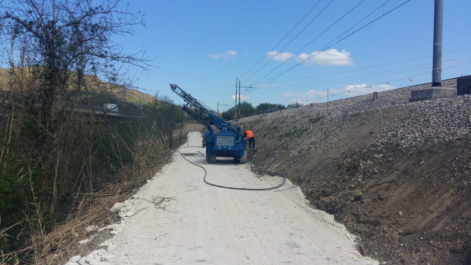 Un camion blu è parcheggiato sul ciglio di una strada sterrata.