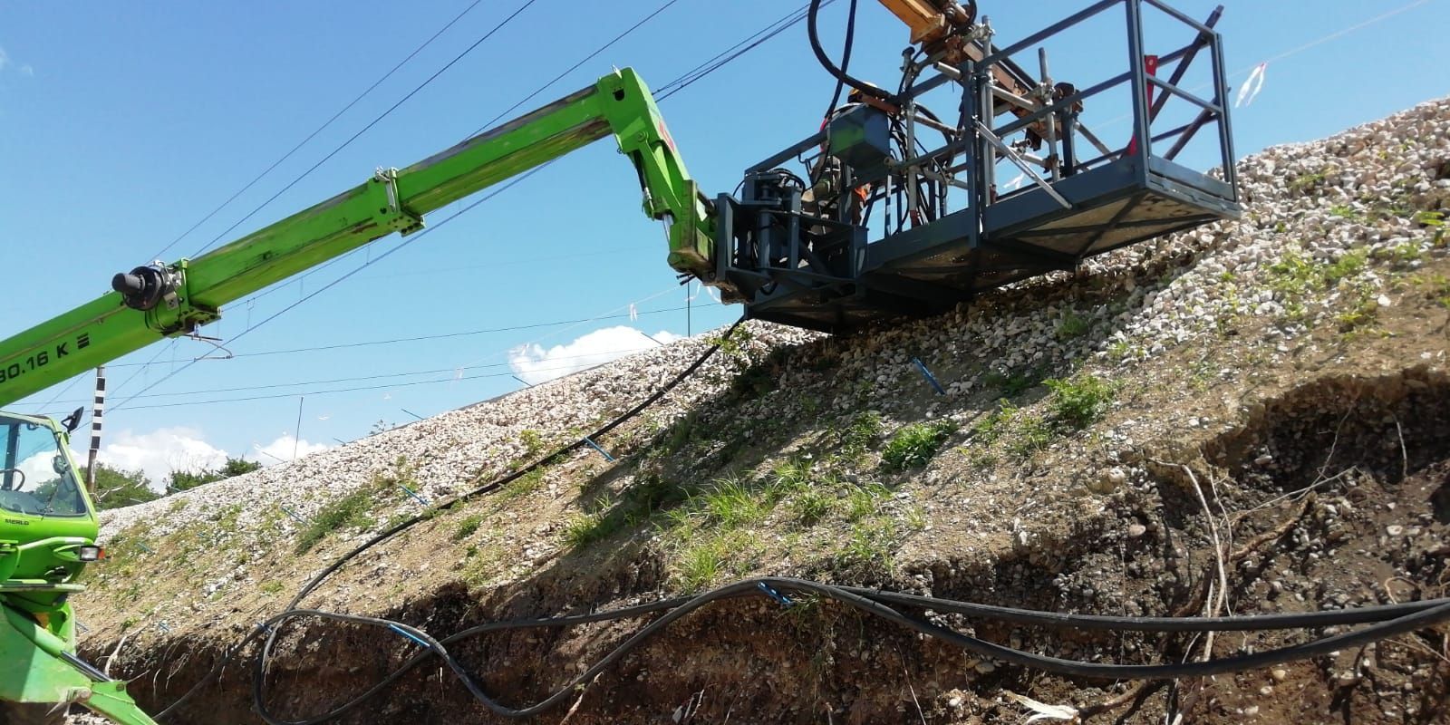 Una gru verde è posizionata in cima a una collina.