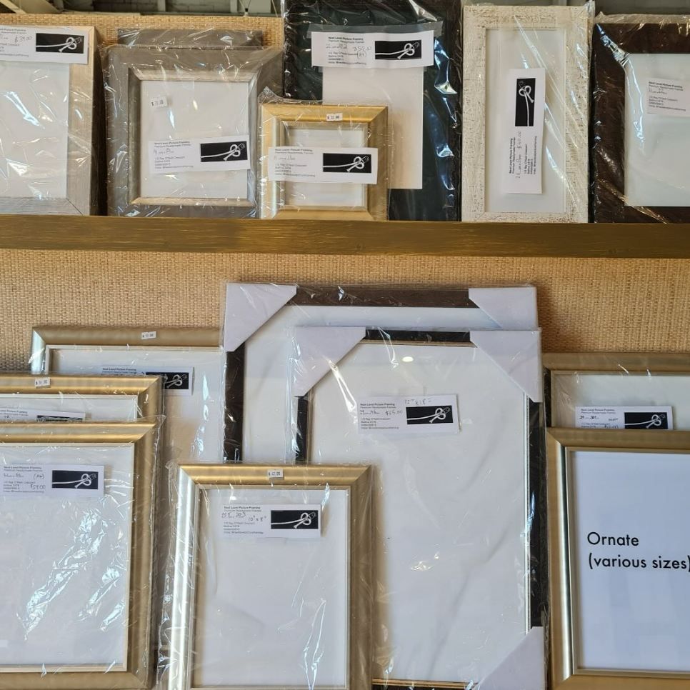 A Bunch of Picture Frames Are Lined Up on a Shelf — Next Level Picture Framing In Ballina, NSW