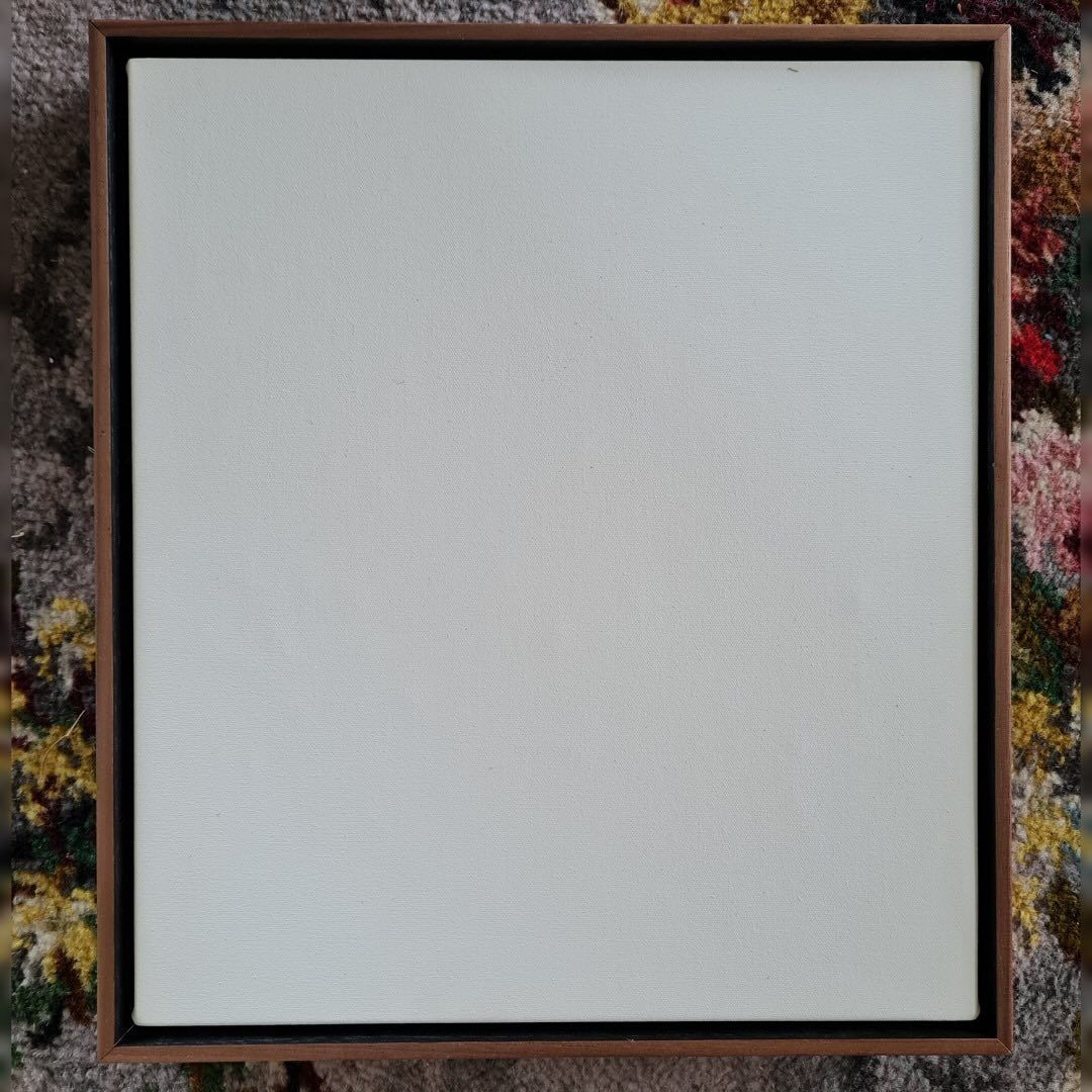 A Square Canvas With a Wooden Frame is Sitting on Top of a Floral Rug — Next Level Picture Framing In Ballina, NSW