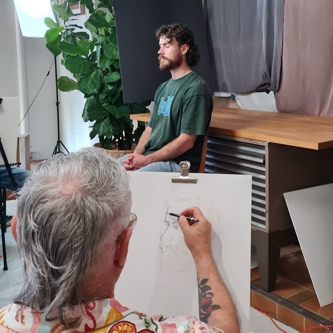 A Man With a Tattoo on His Arm is Drawing on a Piece of Paper — Next Level Picture Framing In Ballina, NSW