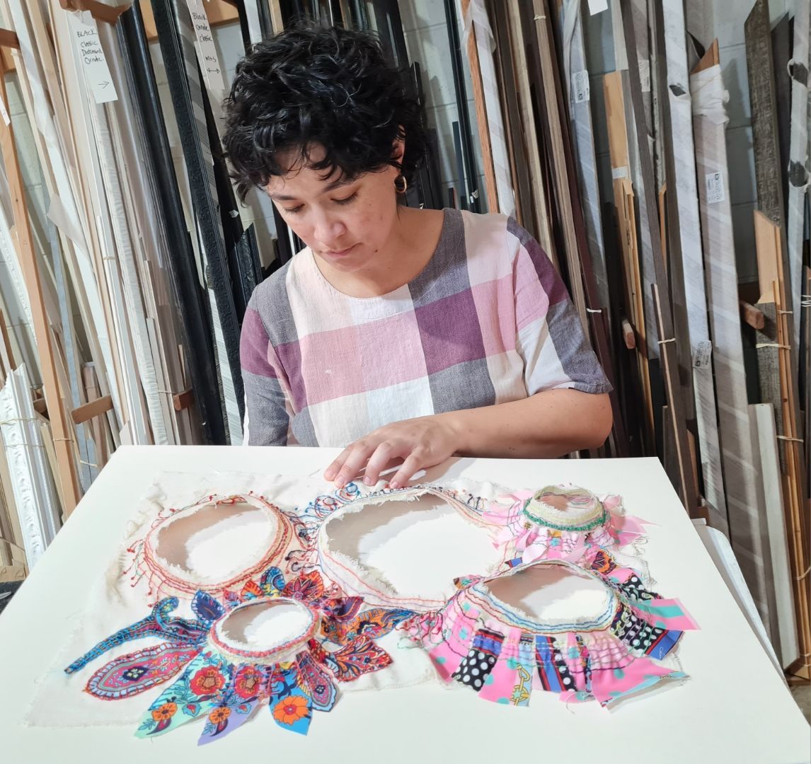 A Lady is placing materials on a canvas — Next Level Picture Framing In Ballina, NSW