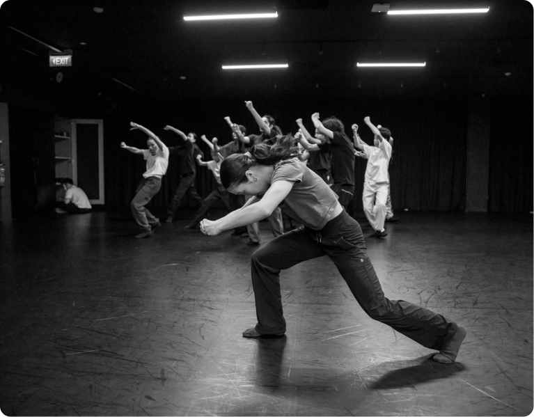 A group of people are dancing in a dark room