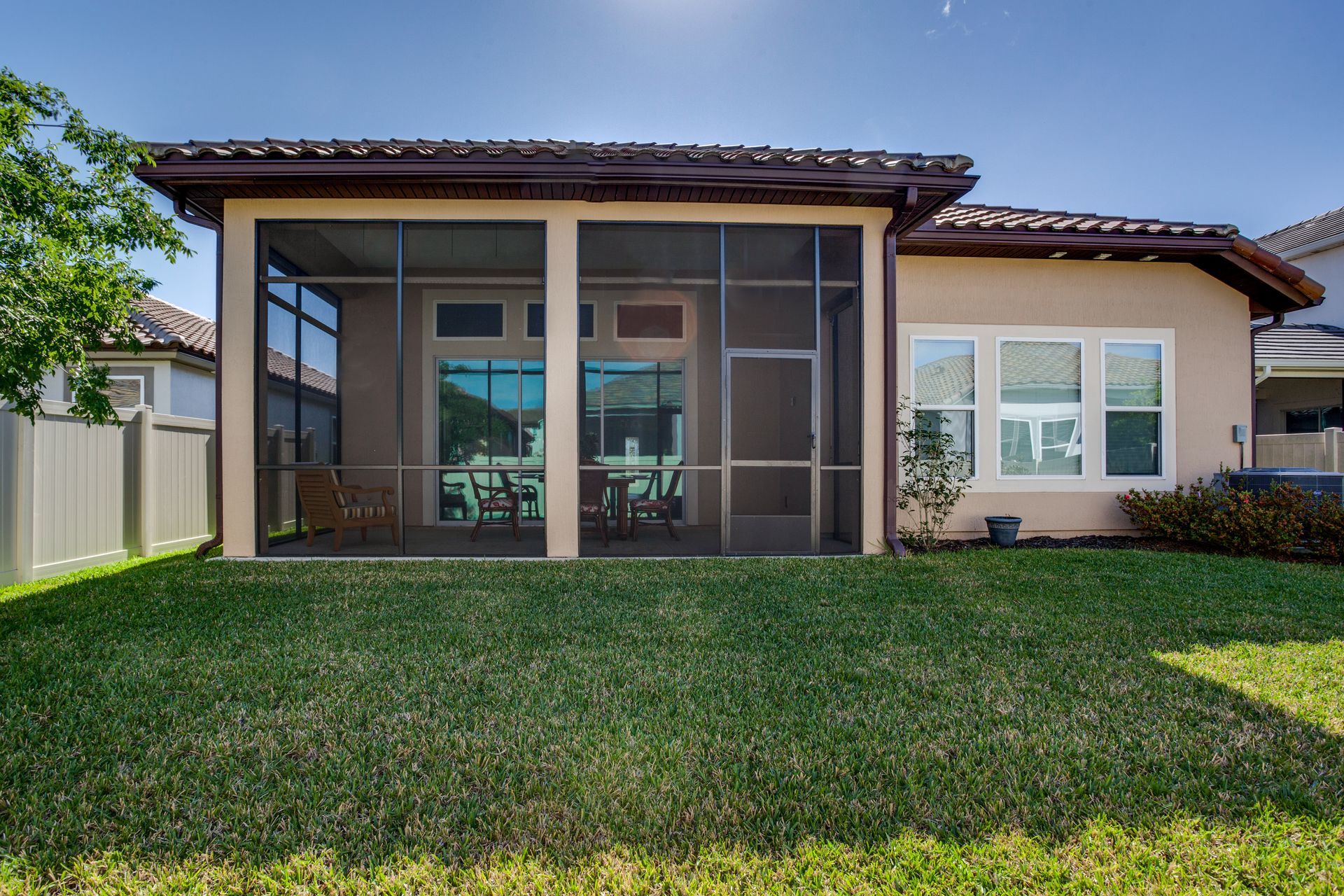 A house with a screened in porch in the backyard