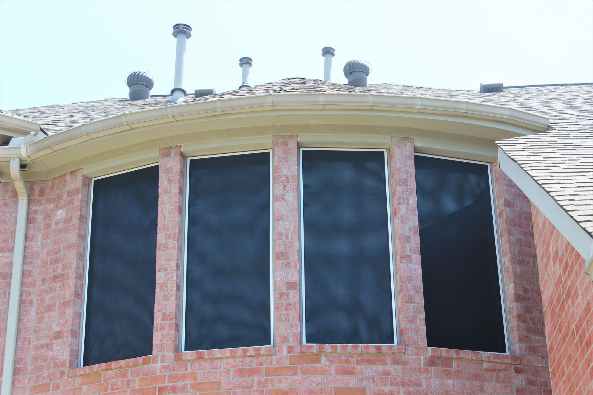 A brick building with a curved roof and a lot of windows