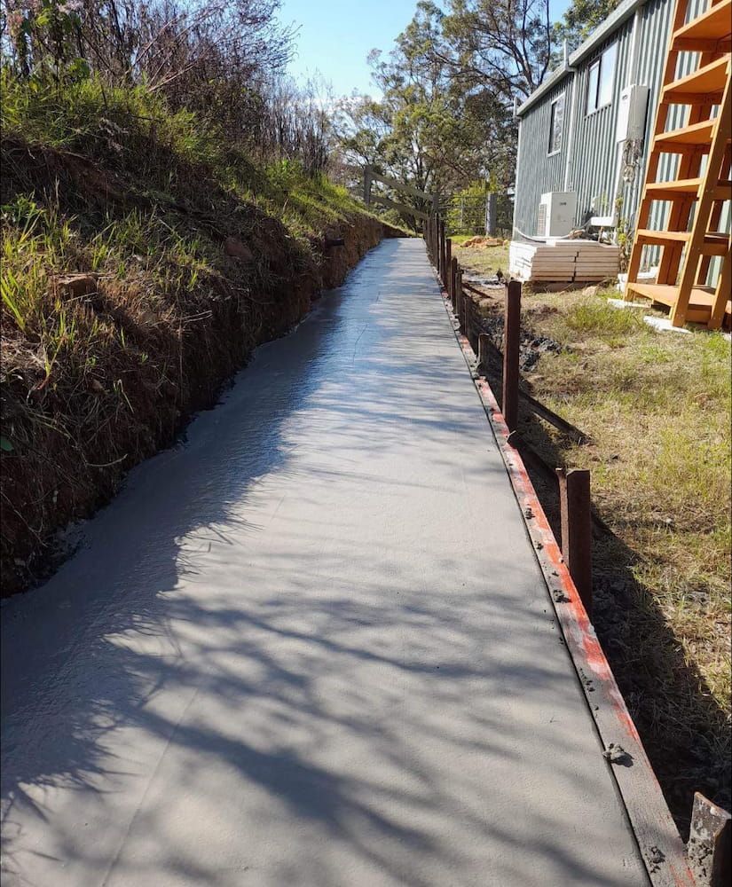 Freshly Poured Concrete Pathway With Wooden Side Supports Alongside — JDC Concreting in Grafton, NSW