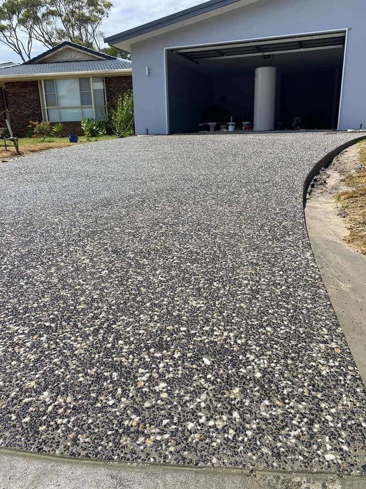 Gravel Driveway Leading to a Garage.  the Driveway is Speckled Gray and White — JDC Concreting in Grafton, NSW