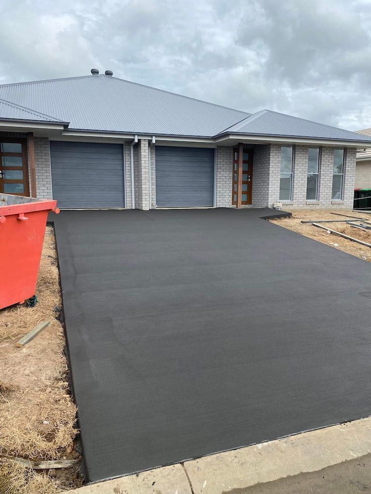 New Asphalt Driveway in Front of a Modern Duplex With Gray Garage Doors — JDC Concreting in Lismore, NSW