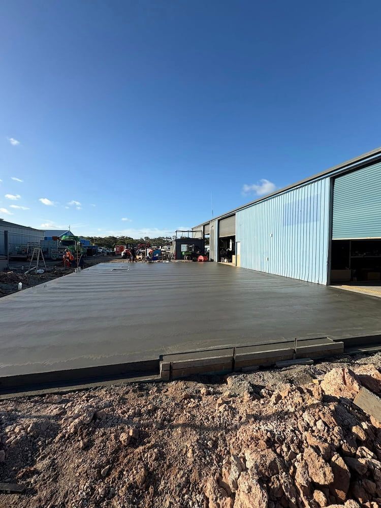 Newly Poured Concrete Slab in Front of a Building Under Construction — JDC Concreting in Grafton, NSW