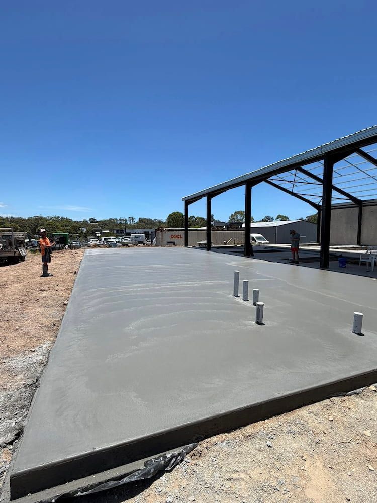 Construction Site: Freshly Poured Concrete Slab With Steel Framework and Workers — JDC Concreting in Grafton, NSW