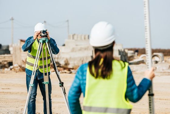 a woman in a yellow vest and a man in a white hard hat