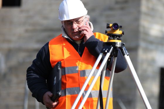 a man wearing a hard hat talking on a cell phone