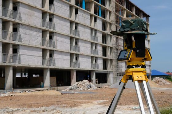 a tripod with a hat on top of it in front of a building