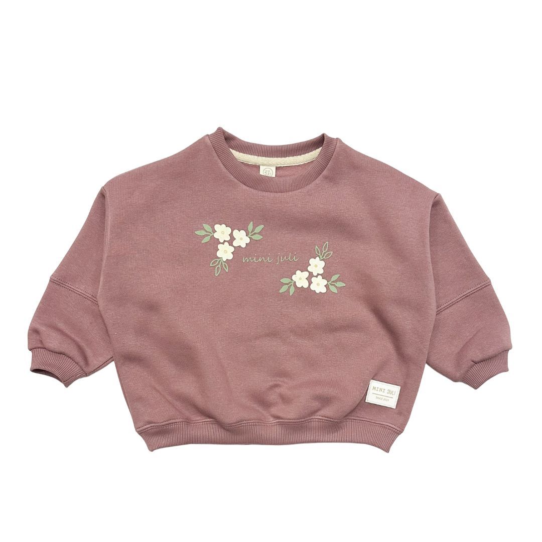 Sudadera rosa con bordado floral y mangas largas, extendida sobre un fondo blanco.