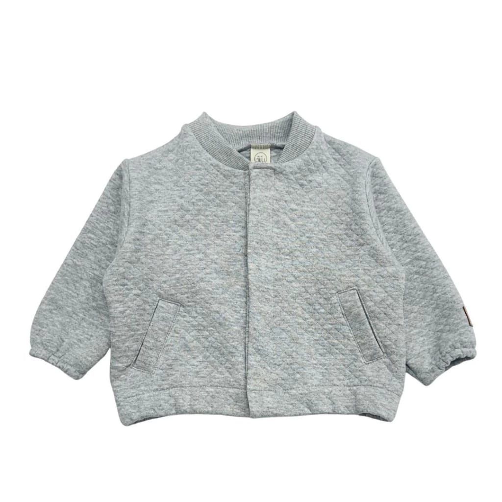Chaqueta texturizada de color gris claro con mangas tres cuartos y bolsillos delanteros sobre fondo blanco.
