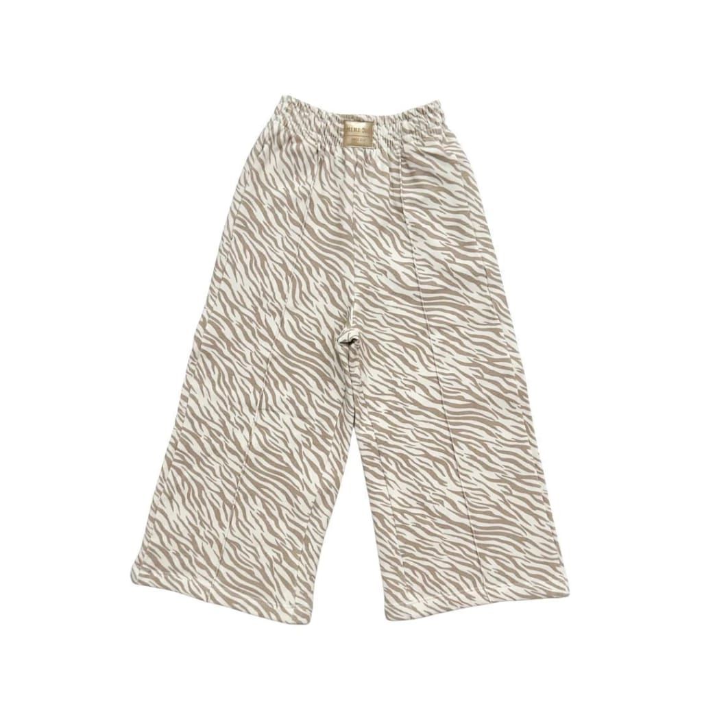 Pantalones anchos con estampado de cebra color beige aislados sobre fondo blanco.