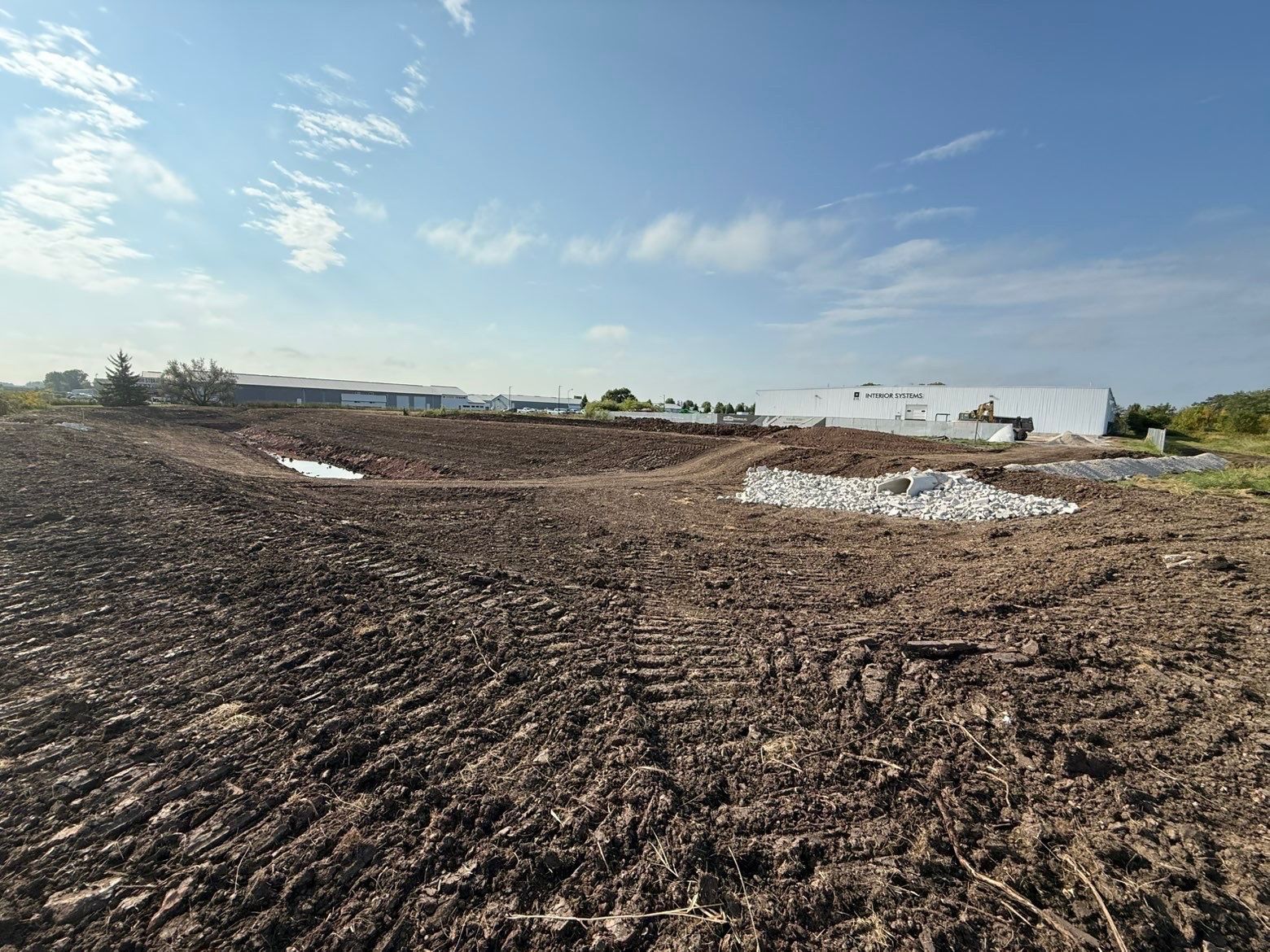 A bulldozer and an excavator are working on a dirt field.