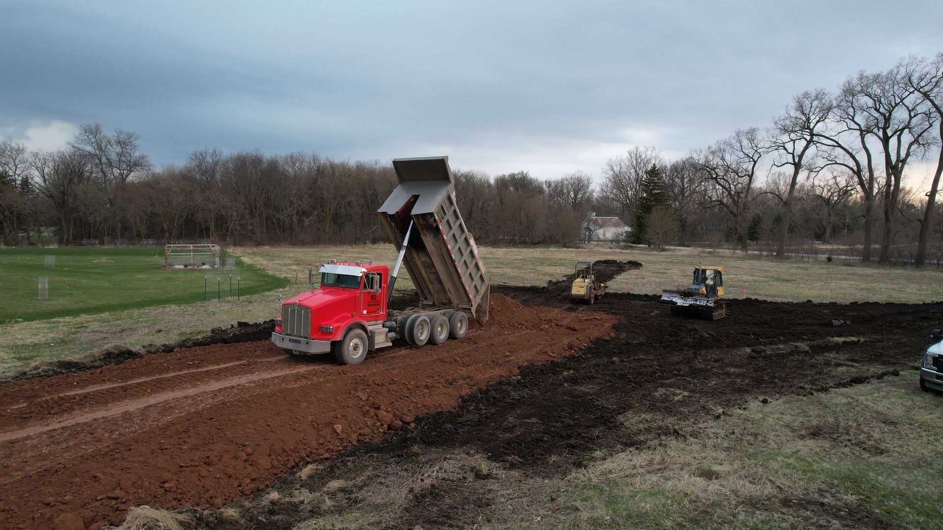 A white dump truck is driving down a road.