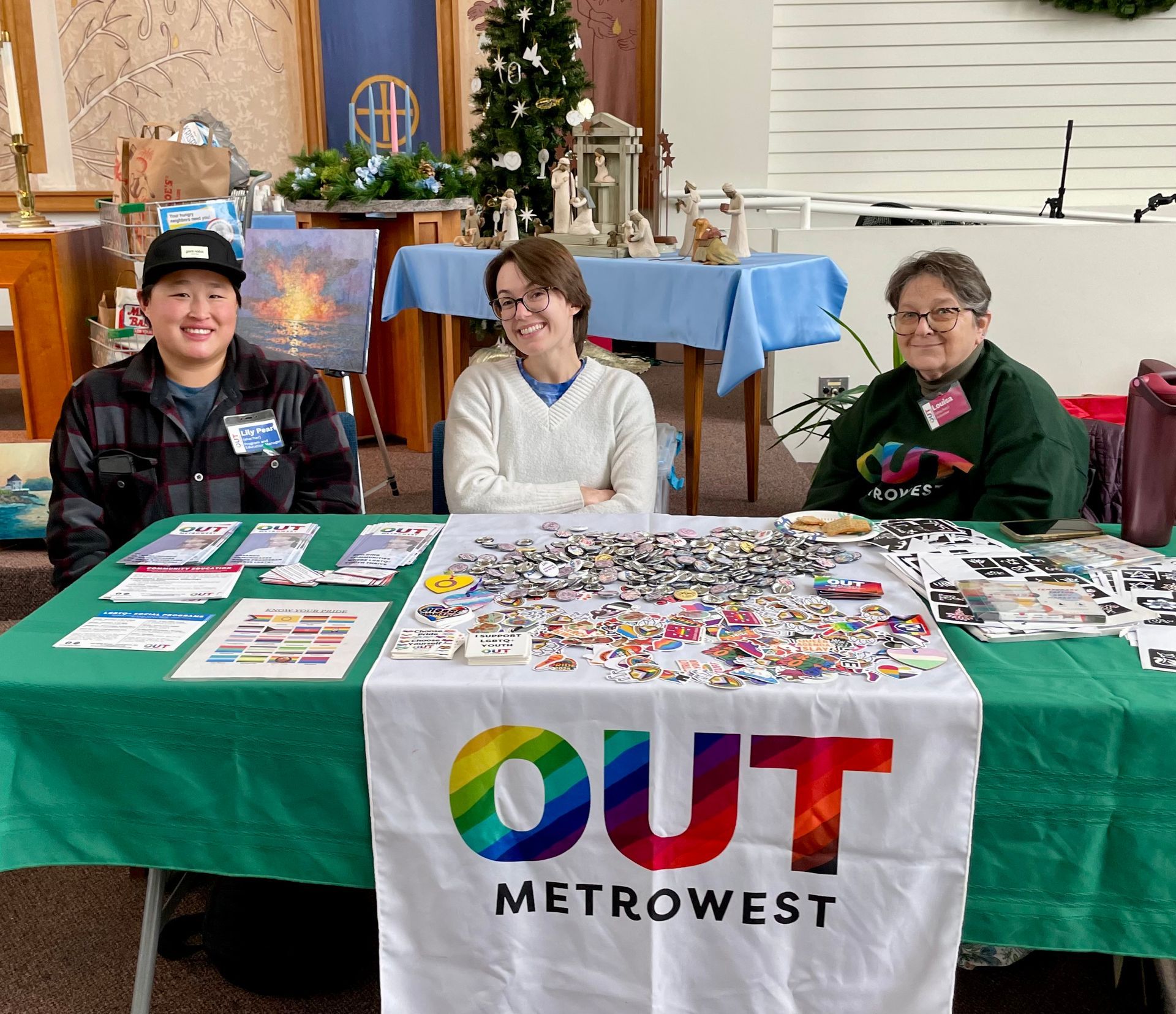 People at an outdoor event with a table displaying