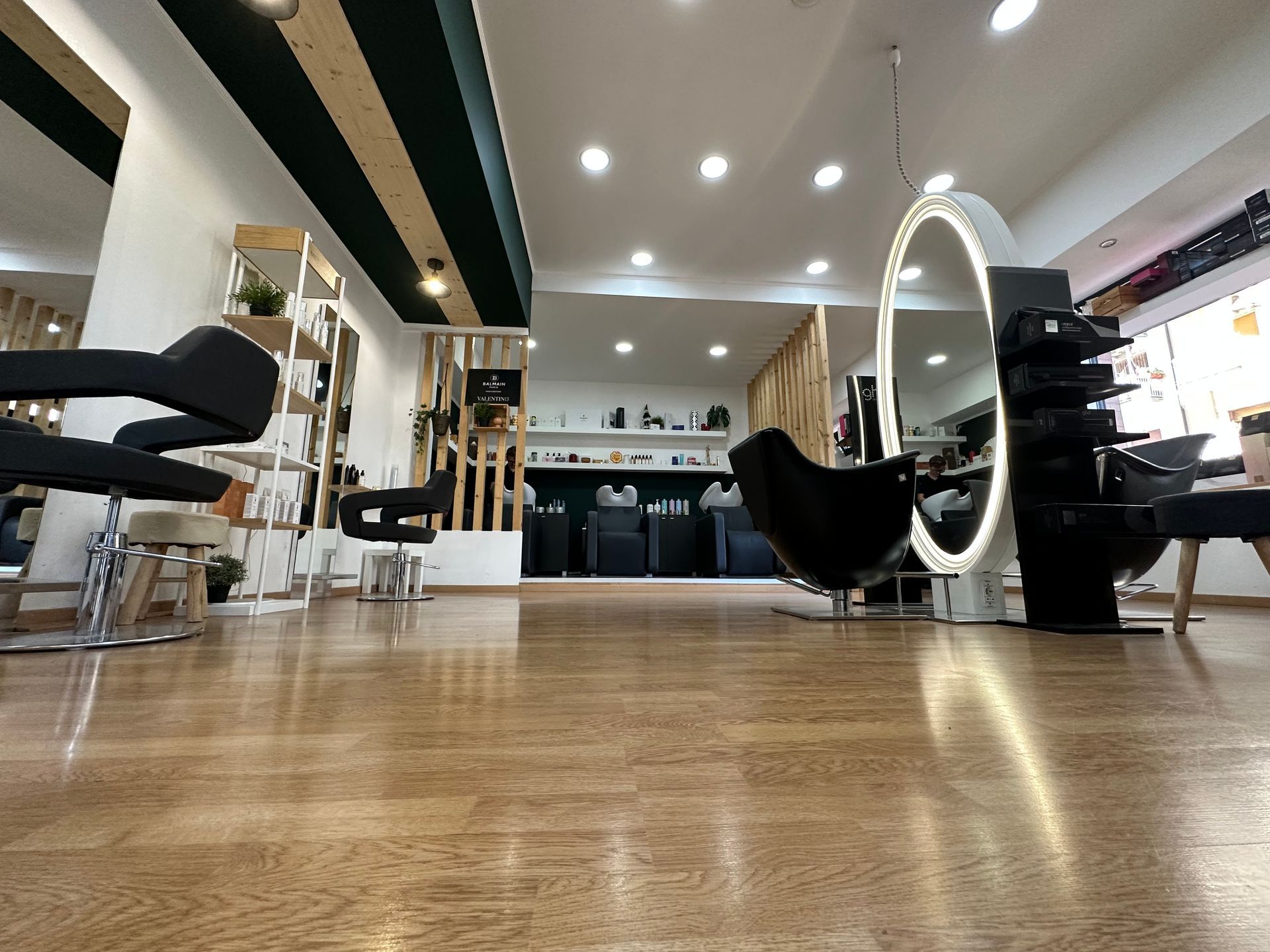 Interno di un salone da parrucchiere con sedie, specchi e postazioni per lo styling.