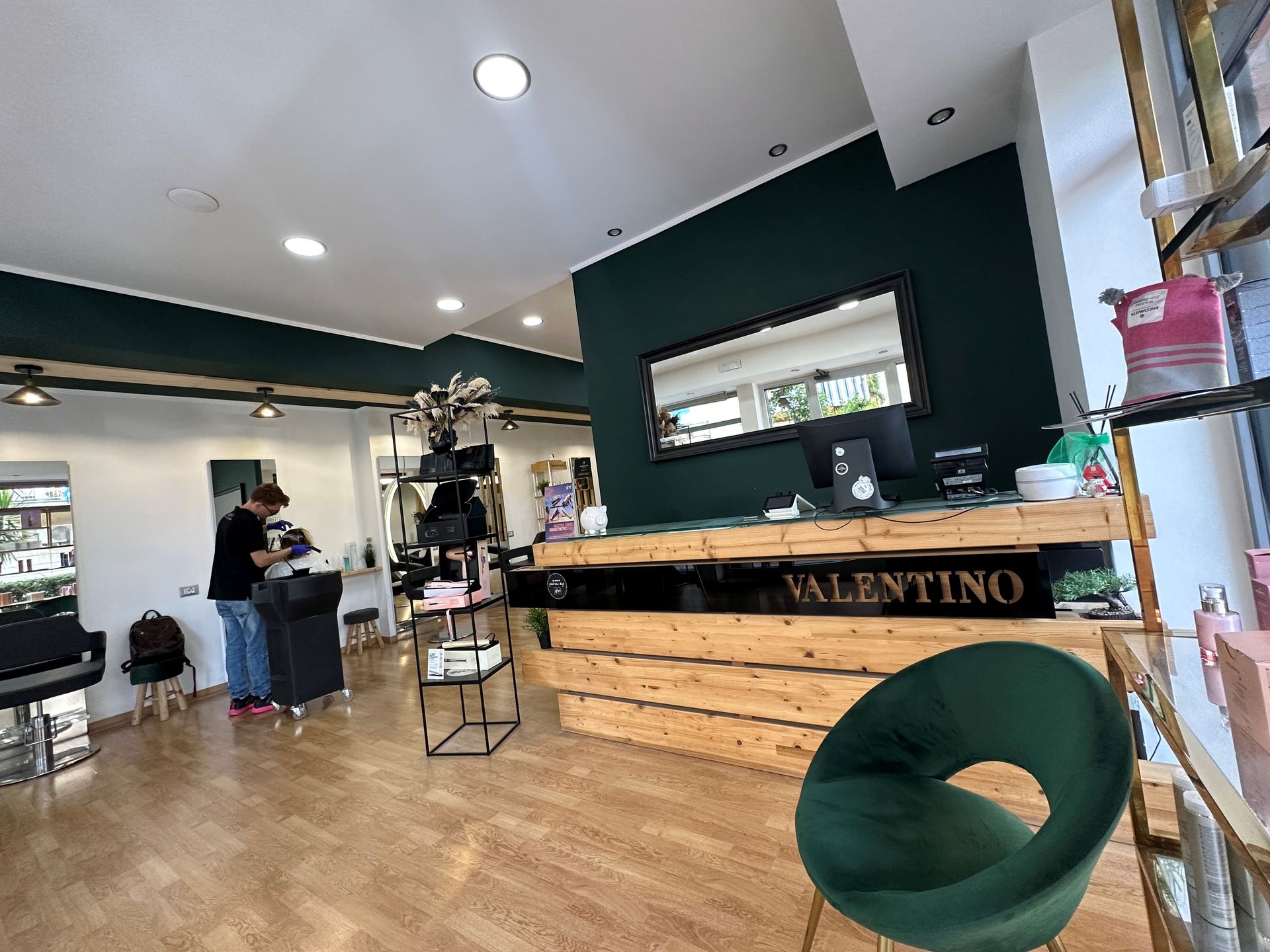 Interno di un salone da parrucchiere; una persona taglia i capelli.