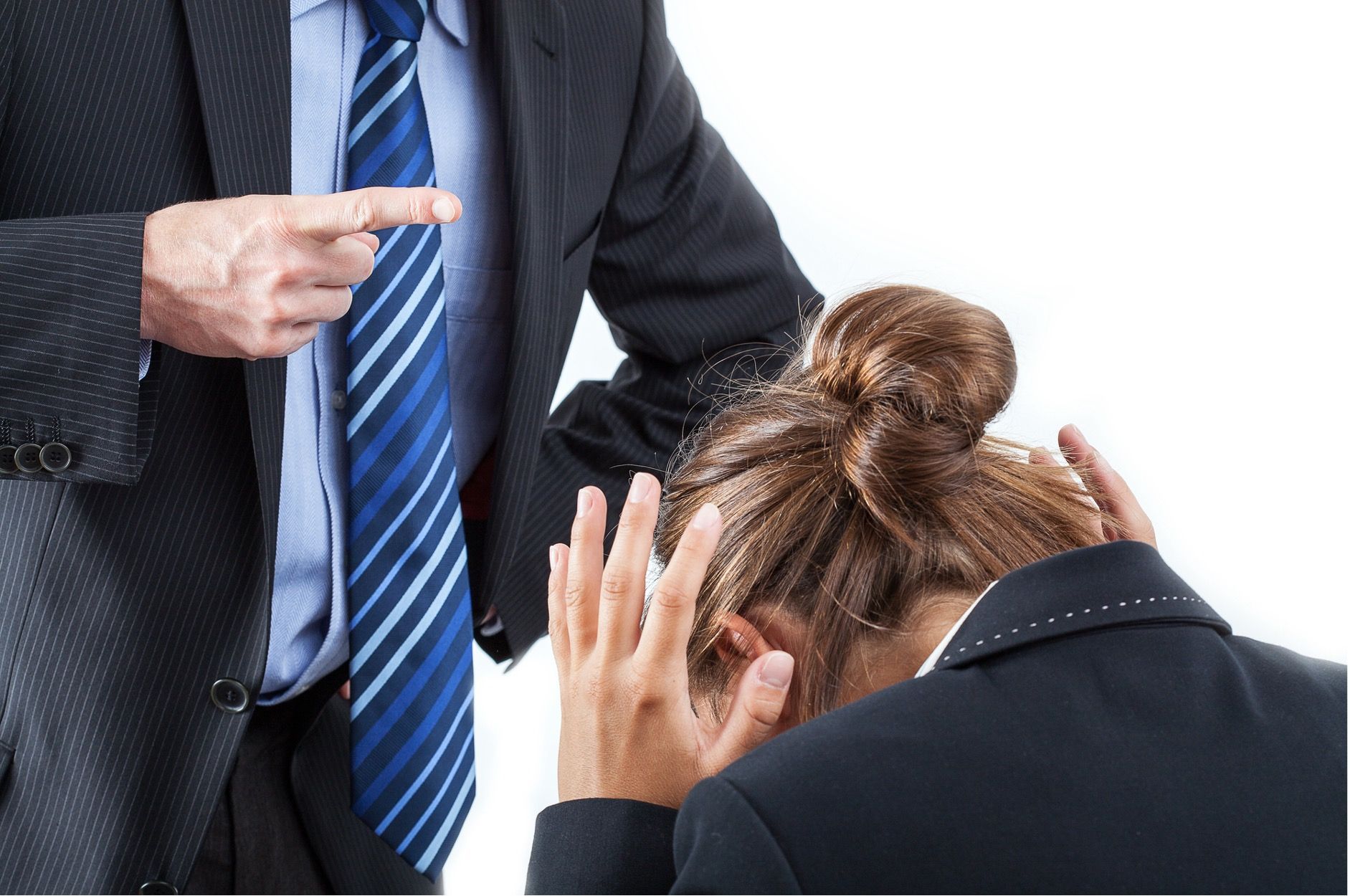 Man in suit pointing at a woman with her head in her hands, possibly reprimanding her.