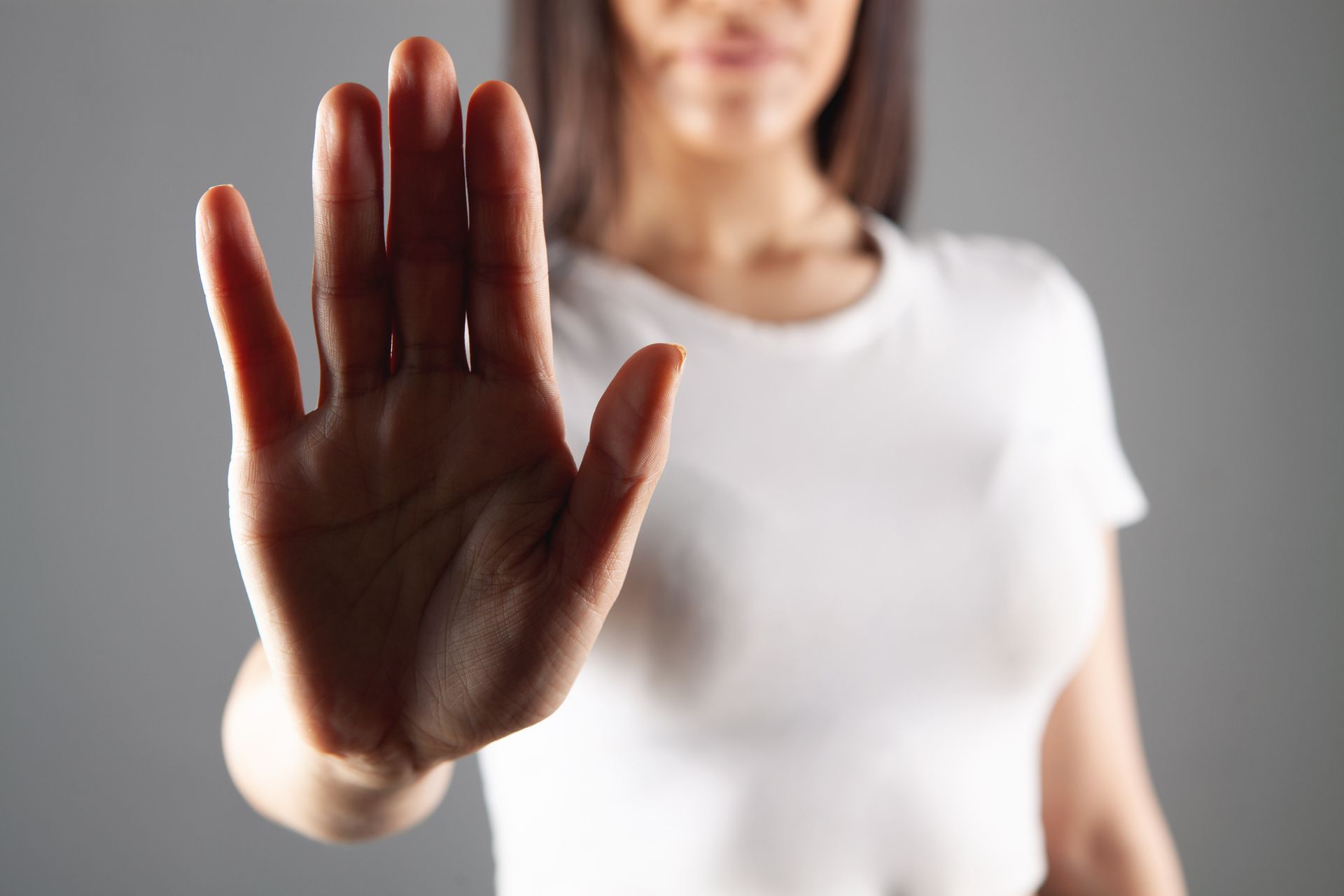 Vrouw maakt een afwijzend gebaar met haar hand om duidelijk haar persoonlijke grens aan te geven.