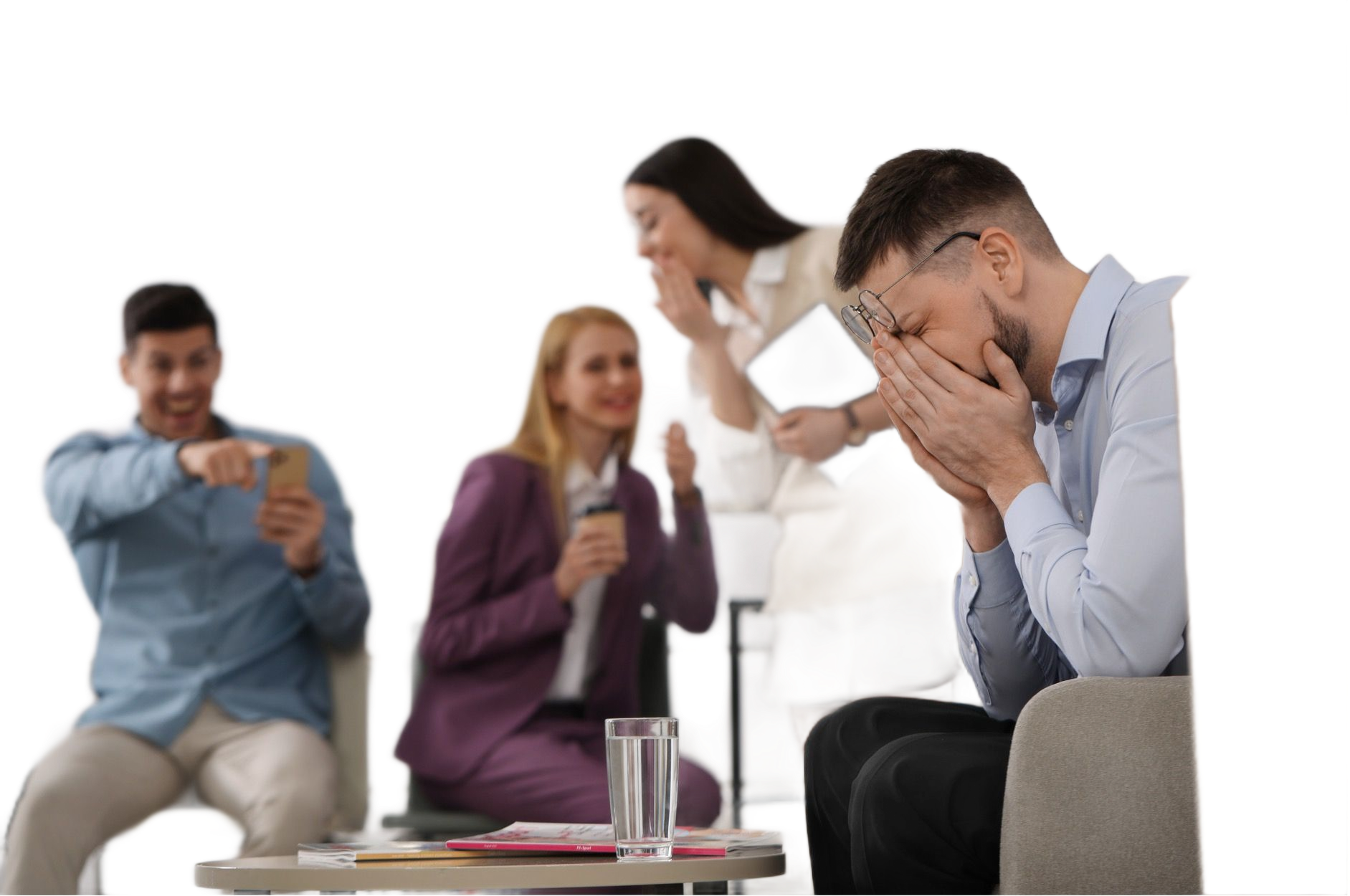 Man in distress covering face, others laughing in background. Office setting.