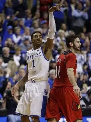 Basketball player in blue jersey shooting a free throw, opponent in red jersey watches.