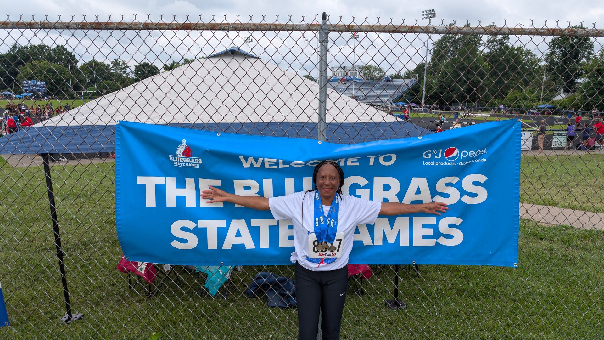 Person with medal stands in front of 