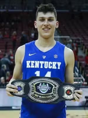 Basketball player in a blue Kentucky jersey holds a belt that says