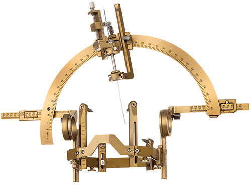 Brain stereotaxic instrument with brass-colored components and arched guide.