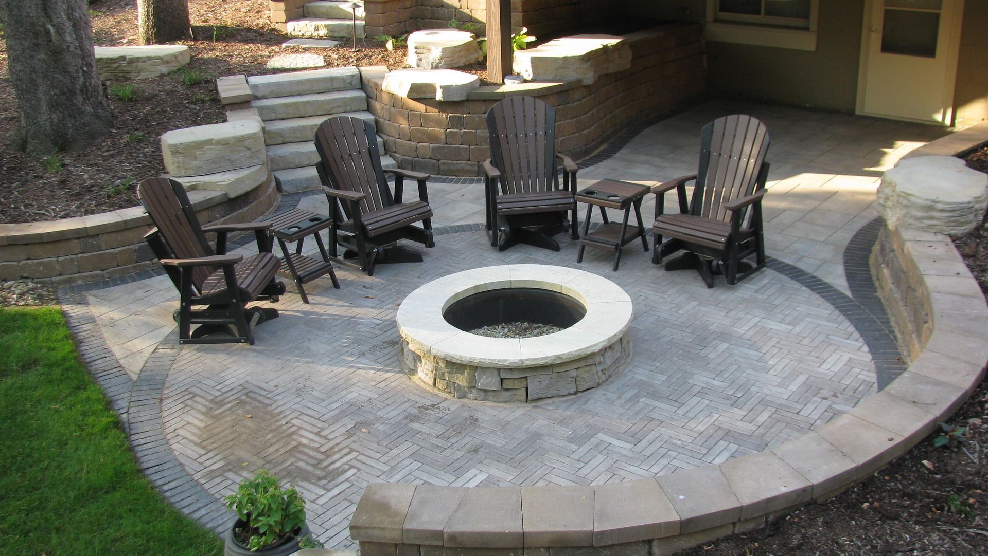 Patio with fire pit, Adirondack chairs, and stone retaining walls.