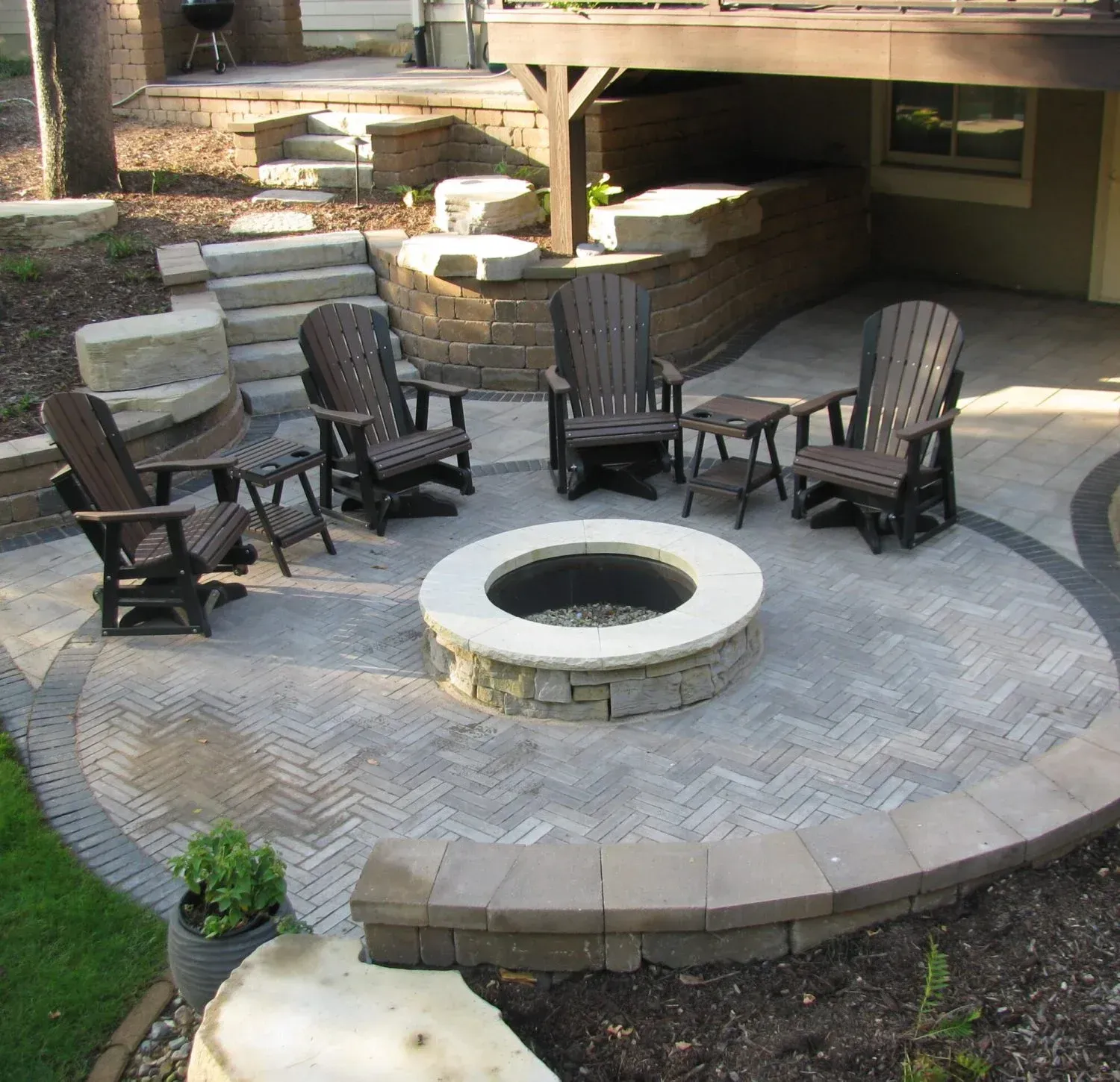 A fire pit is surrounded by chairs and tables — Waterloo, IA — Matthias Landscaping Co