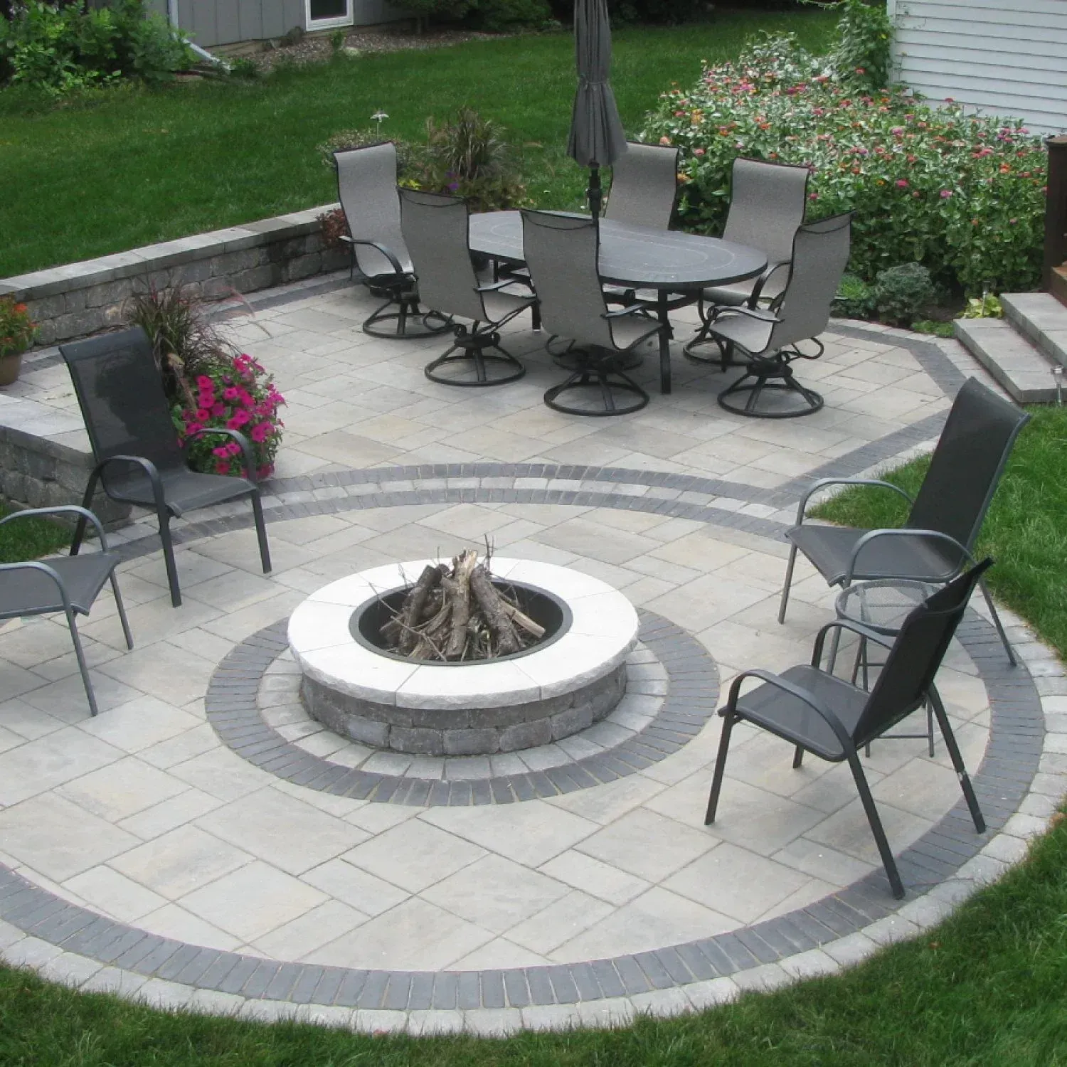 A fire pit with a table and chairs around it — Waterloo, IA — Matthias Landscaping Co