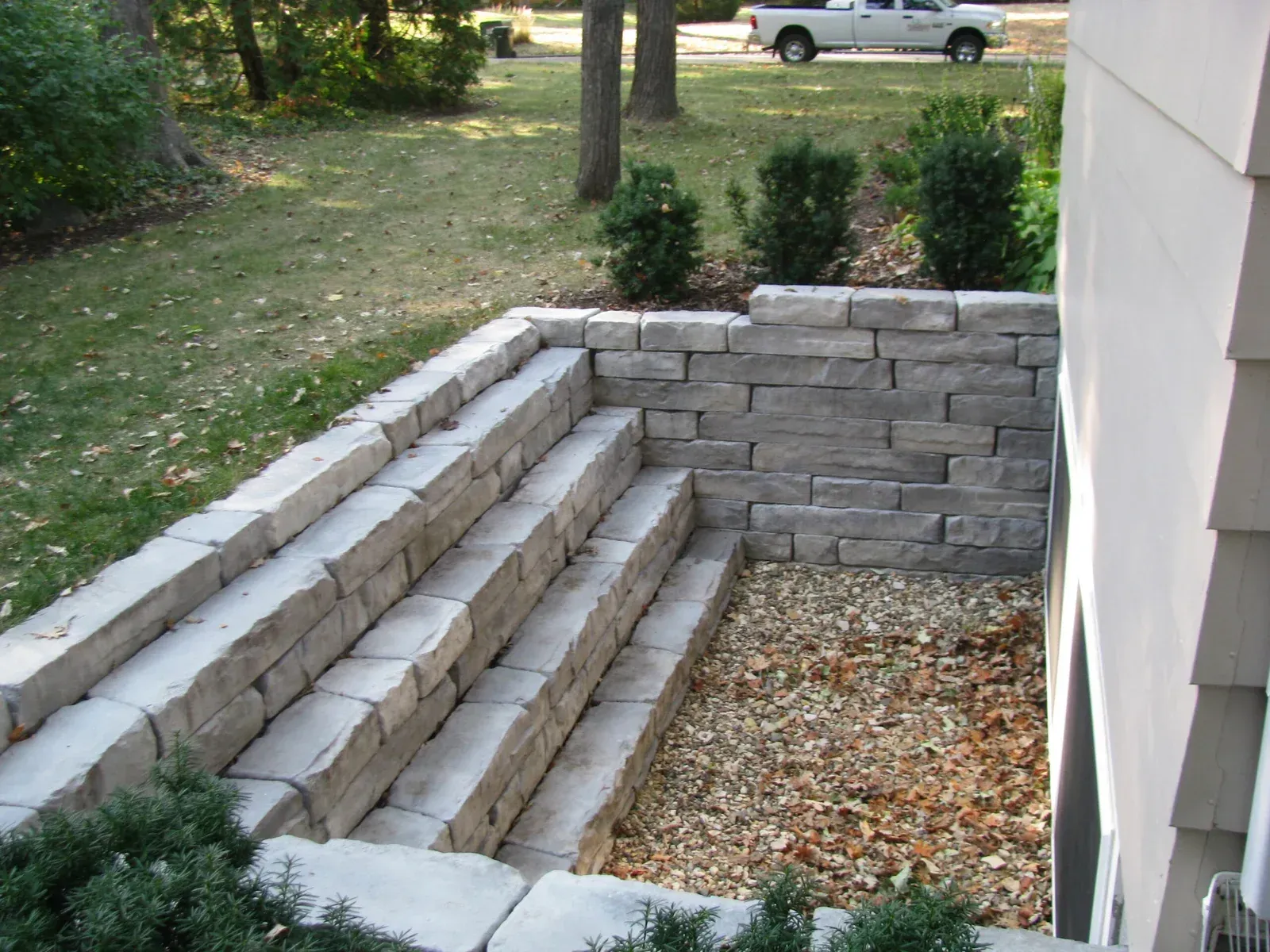 A white truck is parked in front of a brick wall — Waterloo, IA — Matthias Landscaping Co