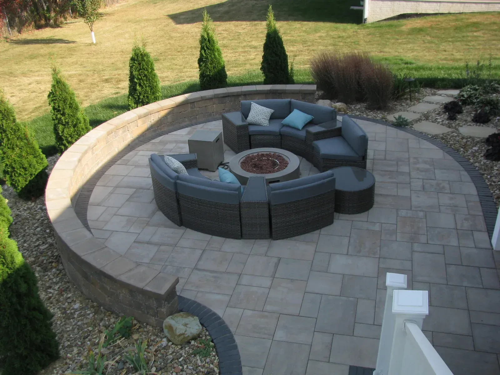 A patio with a fire pit and a couch in the middle — Waterloo, IA — Matthias Landscaping Co